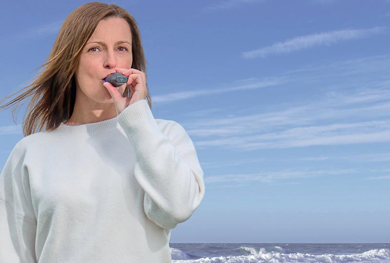 Frau steht am Strand und atmet in das RC-FIT CLASSIC
